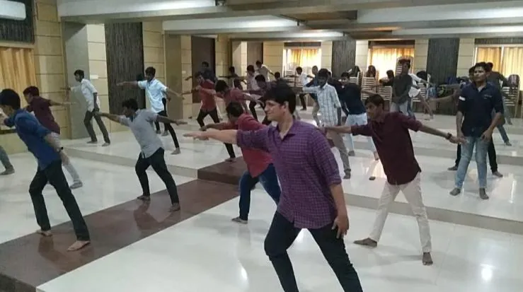 Students following a standing warm-up at the IEEE yoga workshop